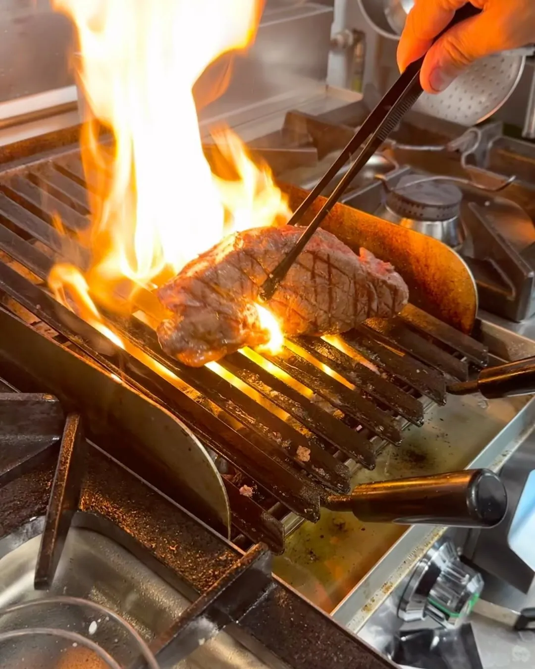Carne sobre la parrilla de La Cocina del Gaidovar, con la llama alta