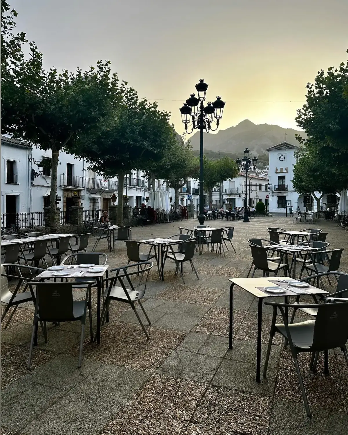 Terraza de La Cocina del Gaidovar en la Plaza de España de Grazalema al atardecer, con las mesas montadas y la sierra al fondo